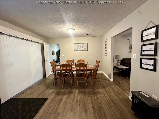 dining room with dark hardwood / wood-style floors and a textured ceiling