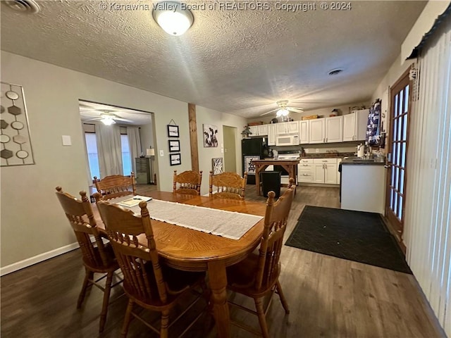 dining space with a textured ceiling and dark hardwood / wood-style floors