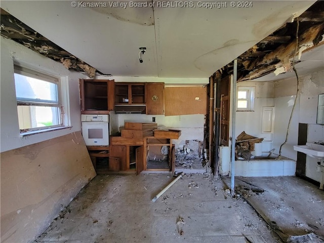 kitchen featuring white oven and a healthy amount of sunlight