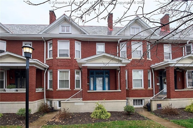 view of front of house featuring brick siding and a chimney