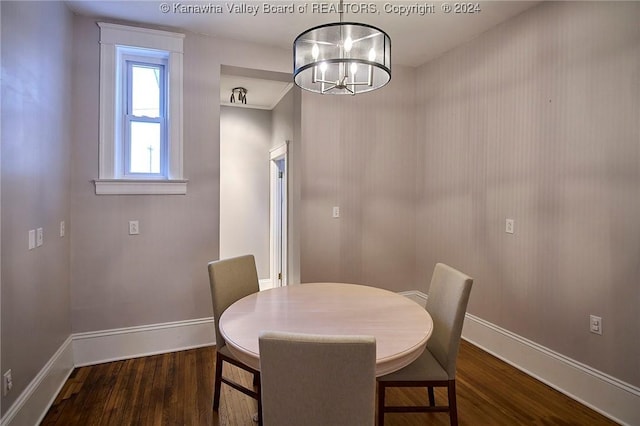 dining space with a notable chandelier, baseboards, and wood finished floors