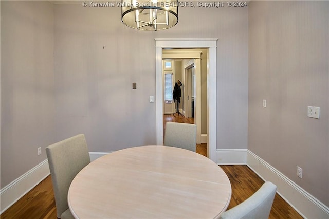 dining area with a notable chandelier, wood finished floors, and baseboards