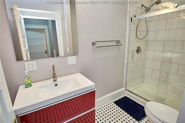 full bath with tile patterned flooring, a shower stall, baseboards, toilet, and vanity