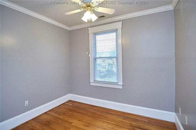 empty room with baseboards, wood finished floors, and crown molding