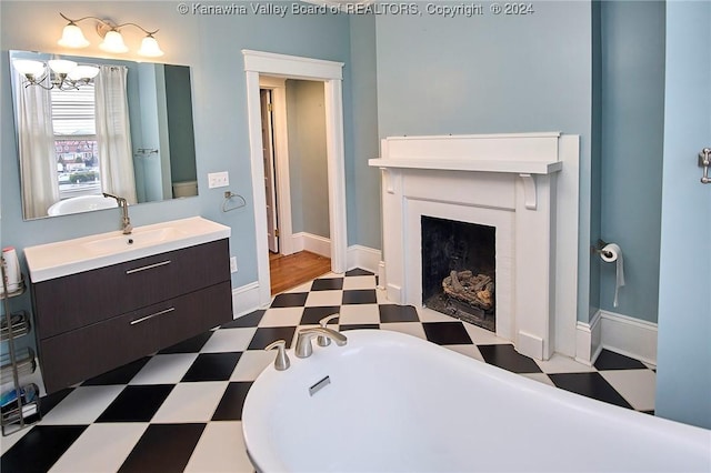 bathroom featuring tile patterned floors, a soaking tub, a chandelier, and vanity