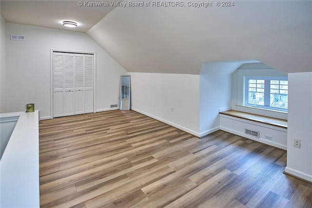 bonus room with wood finished floors, visible vents, and baseboards