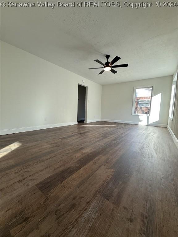 unfurnished room with ceiling fan, dark hardwood / wood-style flooring, and a textured ceiling