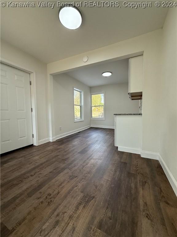 unfurnished living room with dark hardwood / wood-style floors