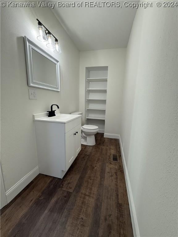 bathroom with vanity, hardwood / wood-style flooring, and toilet