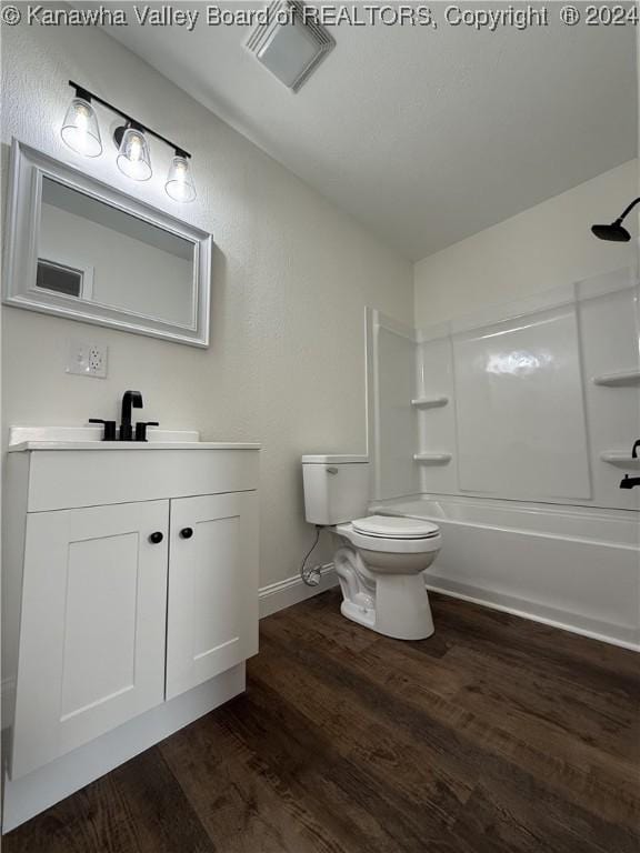 full bathroom with vanity, toilet, wood-type flooring, and bathing tub / shower combination