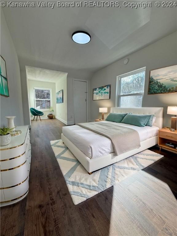 bedroom featuring wood-type flooring and vaulted ceiling