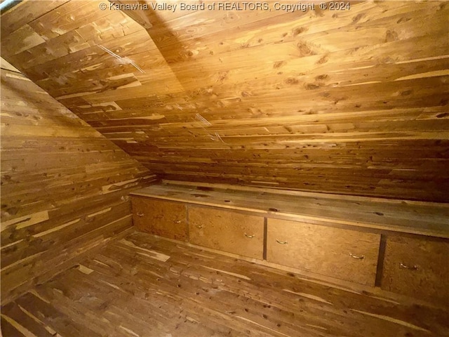 bonus room featuring wood walls and vaulted ceiling