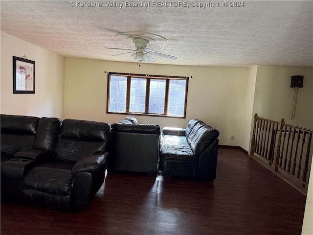 living room featuring ceiling fan, dark hardwood / wood-style flooring, and a textured ceiling