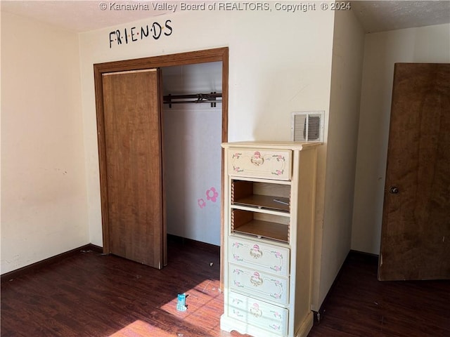 unfurnished bedroom featuring dark wood-type flooring and a closet