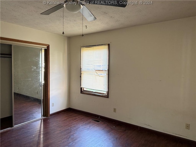 unfurnished bedroom featuring a textured ceiling, dark hardwood / wood-style floors, a closet, and ceiling fan