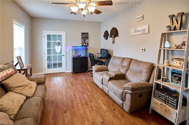 living room featuring a textured ceiling, hardwood / wood-style flooring, and ceiling fan