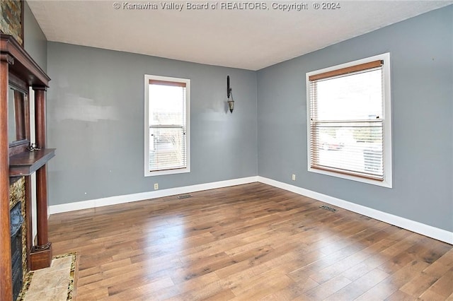 unfurnished living room with a fireplace and hardwood / wood-style floors