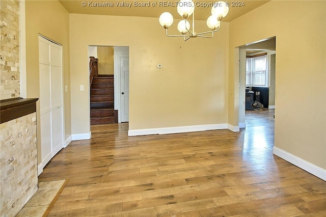 unfurnished dining area with light hardwood / wood-style floors and an inviting chandelier