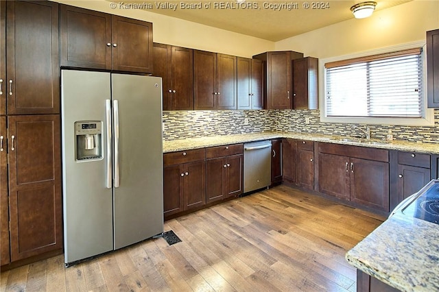 kitchen featuring light stone countertops, sink, and appliances with stainless steel finishes