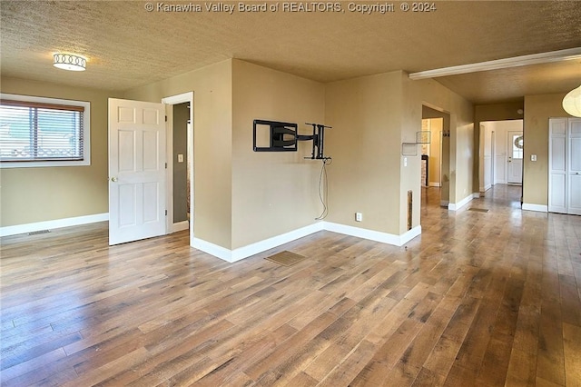 empty room with hardwood / wood-style flooring and a textured ceiling