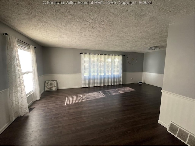 unfurnished room featuring dark hardwood / wood-style floors and a textured ceiling