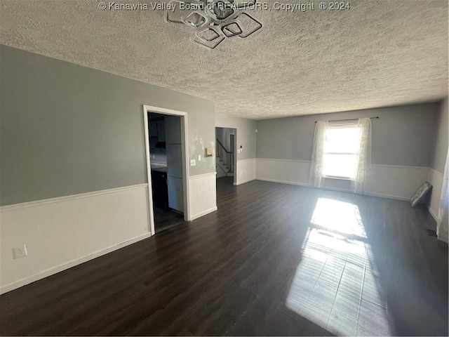 unfurnished room with dark hardwood / wood-style floors and a textured ceiling