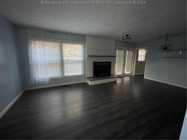 unfurnished living room with french doors, dark wood-type flooring, and a textured ceiling