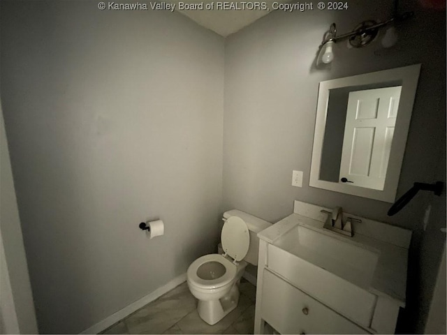 bathroom with tile patterned flooring, vanity, and toilet