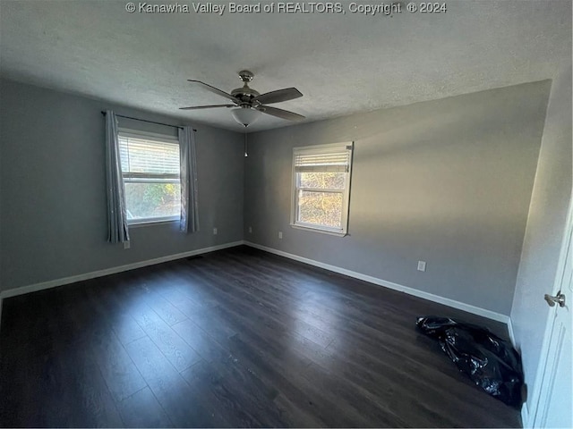 unfurnished room featuring a textured ceiling, dark hardwood / wood-style floors, and ceiling fan