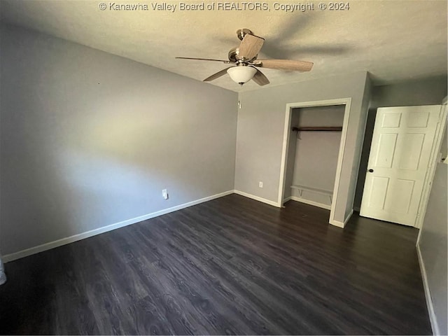 unfurnished bedroom featuring a textured ceiling, ceiling fan, dark wood-type flooring, and a closet