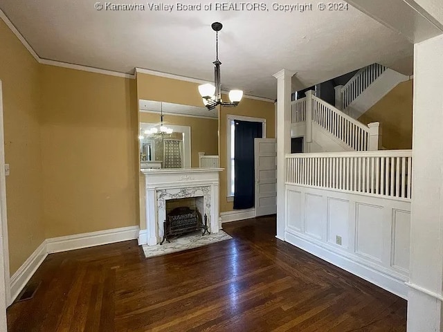 unfurnished living room featuring an inviting chandelier, a high end fireplace, dark hardwood / wood-style floors, and ornamental molding