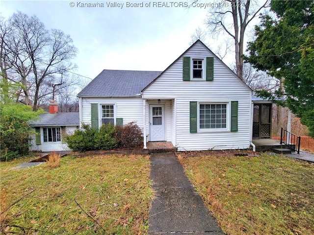 view of front of house with a front lawn and a sunroom