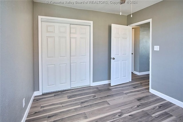 unfurnished bedroom featuring hardwood / wood-style floors and a closet