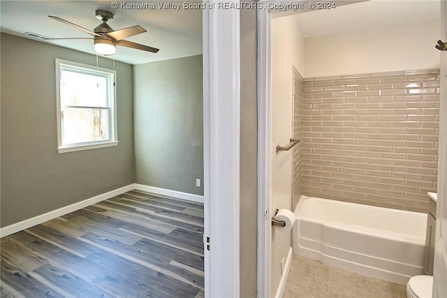 bathroom featuring hardwood / wood-style floors, ceiling fan, toilet, and tiled shower / bath