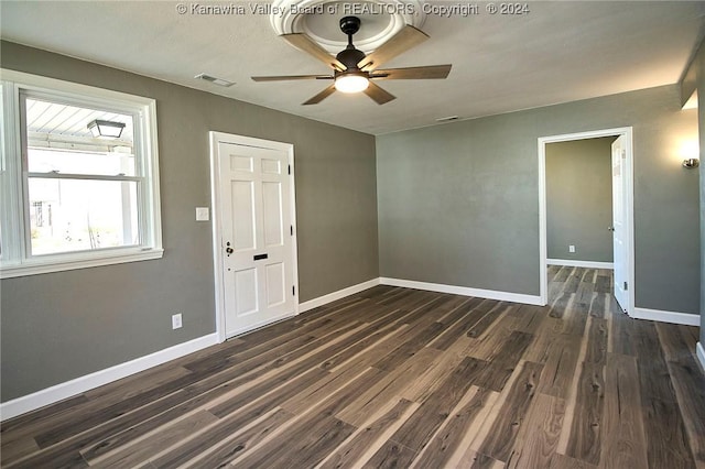 spare room with ceiling fan and dark wood-type flooring