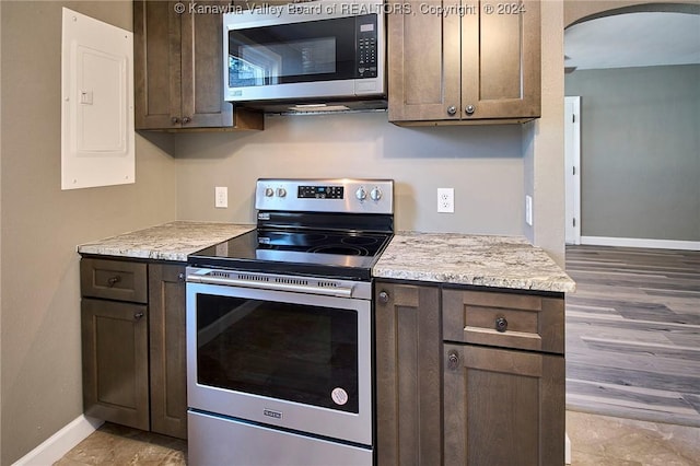 kitchen with electric panel, dark brown cabinets, and appliances with stainless steel finishes