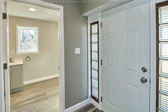 foyer entrance featuring sink and light hardwood / wood-style flooring