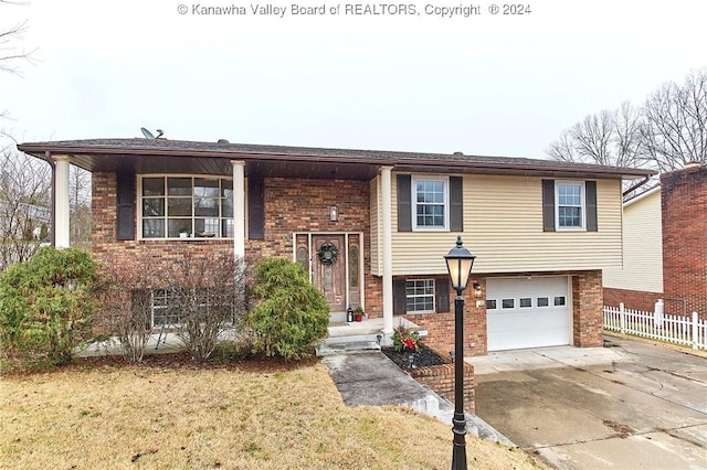 bi-level home featuring a garage and a front lawn