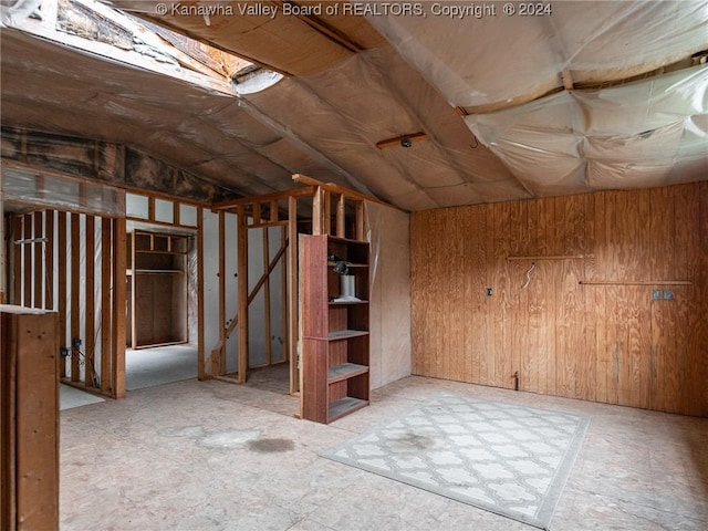 basement featuring wooden walls