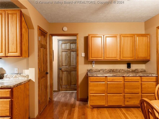 kitchen featuring wood-type flooring and a textured ceiling