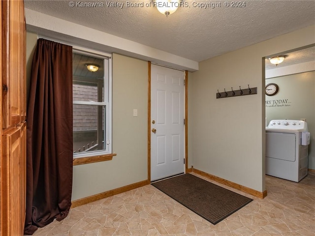 entrance foyer featuring washer / dryer and a textured ceiling