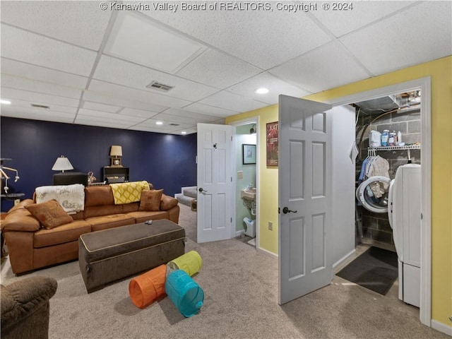 carpeted living room with separate washer and dryer and a drop ceiling