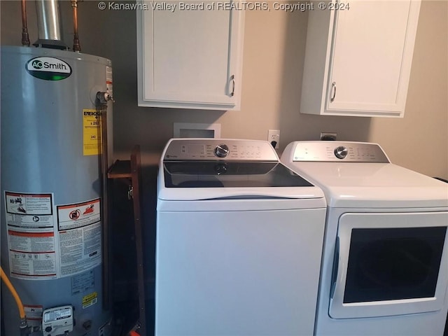 washroom featuring cabinets, washing machine and dryer, and gas water heater