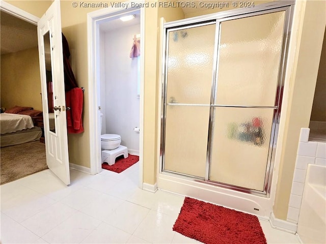 bathroom with tile patterned flooring, toilet, and walk in shower