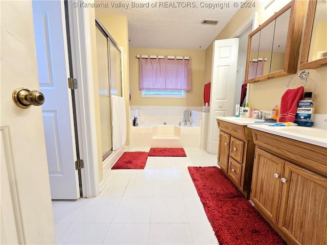 bathroom with tile patterned flooring, vanity, a textured ceiling, and plus walk in shower