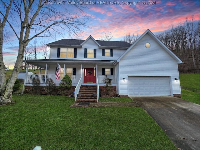 view of front of property featuring covered porch, a garage, and a yard