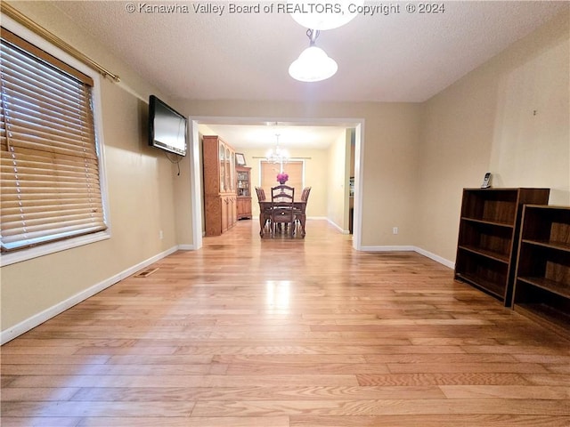 interior space featuring light wood-type flooring and a notable chandelier