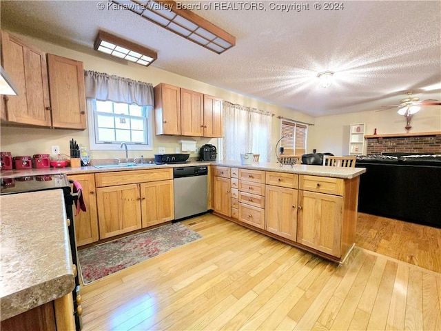 kitchen with kitchen peninsula, dishwasher, a textured ceiling, and sink