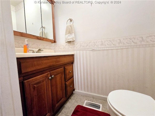 bathroom with tile patterned flooring, vanity, and toilet