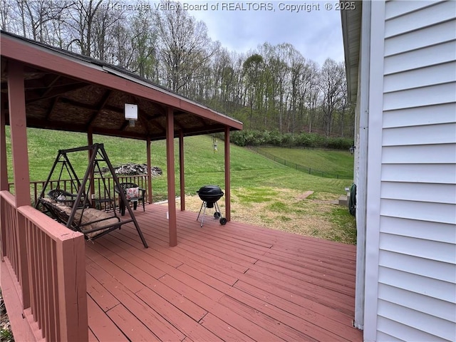 wooden terrace with a gazebo, a lawn, and area for grilling